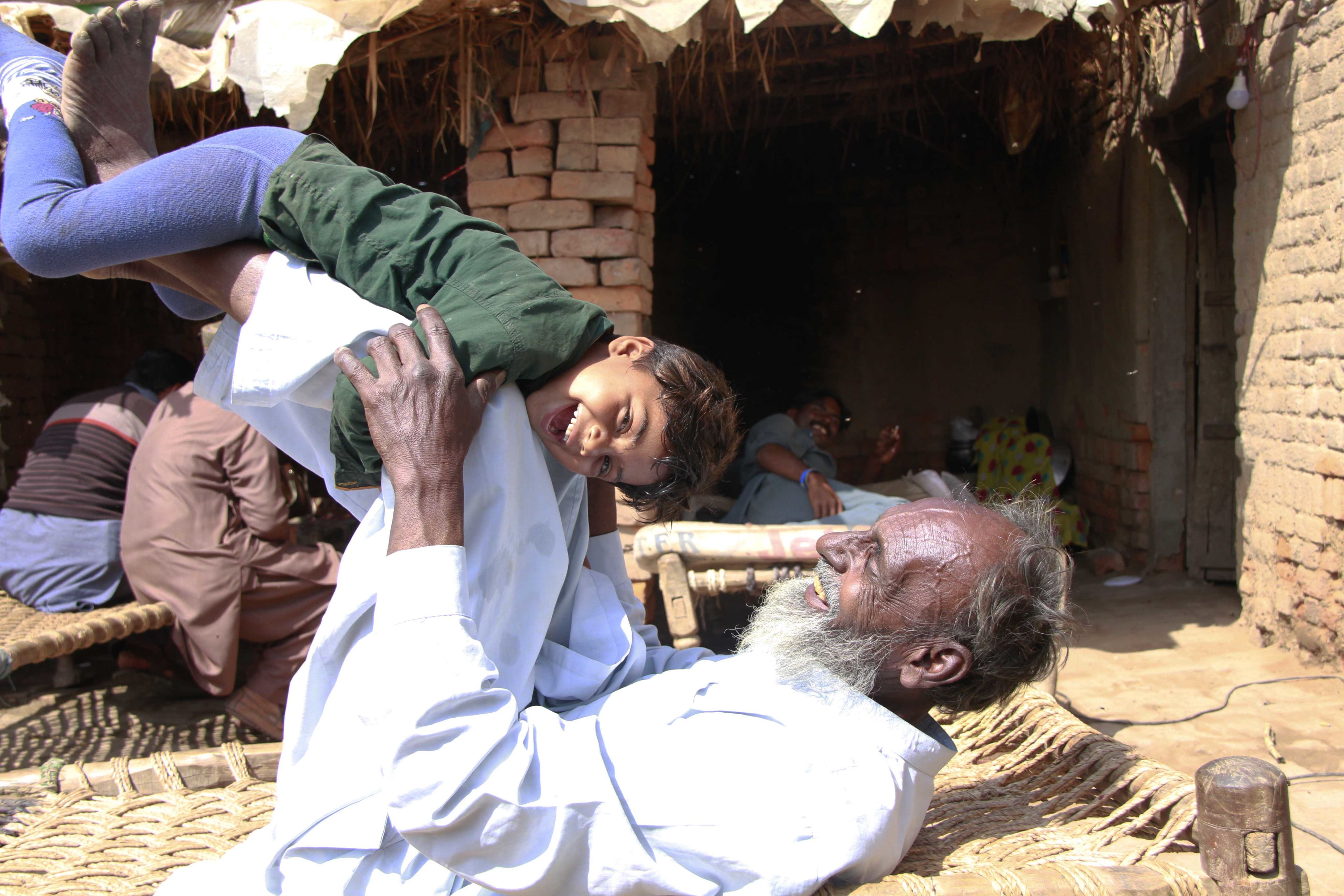 Sardar plays outside with his young grandson. 
